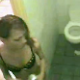 A hidden camera records a pretty girl squatting over a toilet to take a shit. She wipes her ass repeatedly and stands up to reveal a glimpse of her turd in the toilet. No audio. About 2 minutes.